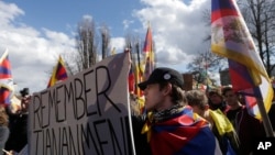 活动人士在捷克共和国首都布拉格挥舞旗帜与自由西藏的旗子参加抗议中国国家主席习近平访问布拉格的集会 (2016年3月29日)