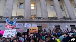 People listen to speakers during a rally against Elon Musk outside the U.S. Treasury Department in Washington, Feb. 4, 2025. 