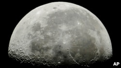 Stasiun Luar Angkasa Internasional, tengah, melintas di depan Bulan di orbit Bumi, Hongaria, 5 Juli 2018. Pada 4 April 2021, perusahaan eksplorasi Bulan, iSpace, mengatakan akan menerbangkan wahana penjelajah milik UEA ke Bulan pada 2022. (Foto: Peter Komka/MTI via AP)