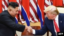 Pemimpin Korea Utara Kim Jong Un (kiri) dan Presiden AS Donald Trump berjabat tangan saat bertemu di Garis Demarkasi Militer yang memisahkan Korea Utara dengan Korea Selatan, 30 Juni 2019. (Foto: dok).