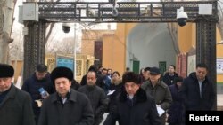 Para Imam dan warga Muslim Uighur melewati kamera keamanan yang dipasang pemerintah China saat keluar dari Masjid Id Kah di kota Kashgar, Xinjiang, China (foto: dok).