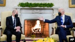 President Joe Biden, right, gestures during a meeting with German Chancellor Olaf Scholz in the Oval Office of the White House, in Washington, Feb. 7, 2022.