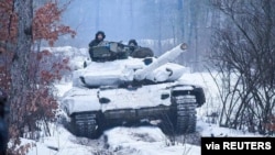 Service members of the Ukrainian Armed Forces ride atop of a tank during military drills in the Donetsk region, Ukraine, in this handout picture released Feb. 4, 2022. (Press service of the Joint Forces Operation/Handout via Reuters)