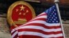 FILE - The American flag is flown next to the Chinese national emblem during a welcome ceremony for visiting U.S. President Donald Trump outside the Great Hall of the People in Beijing, Nov. 9, 2017. 