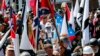 FILE - White nationalist demonstrators walk into the entrance of Lee Park surrounded by counterdemonstrators in Charlottesville, Va., Aug. 12, 2017. 