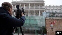 FILE - A cameraman films the Hotel Palais Coburg, venue of the meeting of countries party to the Iran nuclear deal, known as the Joint Comprehensive Plan of Action (JCPOA), in Vienna, Austria Feb. 8, 2022.