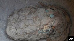 Sebuah mumi terlihat di lokasi penggalian di mana sekelompok arkeolog menemukan enam mumi anak-anak di Cajamarquilla, di dekat Lima, Peru, pada 13 Februari 2022. (Foto: AP/Martin Mejia)