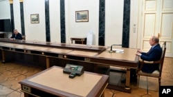 Russian President Vladimir Putin, right, meets with Russian Russian Defense Minister Sergei Shoigu, left, in Moscow, Russia, Feb. 14, 2022.