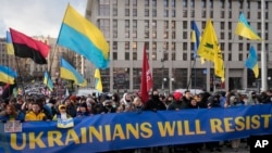 Ukrainians attend a rally in central Kyiv, Ukraine, Saturday, Feb. 12, 2022, during a protest against the potential escalation of the tension between Russia and Ukraine. 