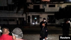 FILE- Police guard the perimeter of a scene where Heber Lopez, a journalist who ran NoticiasWeb, was shot and killed, in Salina Cruz, in Oaxaca state, Mexico Feb. 10, 2022.