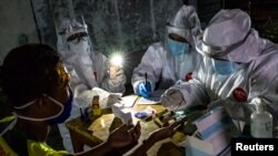 Staf medis mengambil sampel uji cepat dari vendor di pasar tradisional untuk mencegah penyebaran Covid-19 di Semarang, Provinsi Jawa Tengah, 22 Mei 2020. (Foto: Antara via Reuters)