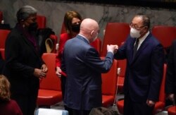 តំណាង​អចិន្ត្រៃយ៍​នៃ​សហព័ន្ធ​រុស្ស៊ី​ប្រចាំ​អង្គការ​សហ​ប្រជាជាតិ​លោក Vasily Nebenzya (កណ្តាល) លើកដៃ​ជល់គ្នា​ជាមួយ​លោក​ឯកអគ្គរដ្ឋទូត Zhang Jun តំណាង​អចិន្ត្រៃយ៍​នៃ​ប្រទេស​ចិន ខណៈ​ដែល​ឯកអគ្គរដ្ឋទូត​អាមេរិក​អ្នកស្រី Thomas-Greenfield និង​តំណាង​អចិន្ត្រៃយ៍​នៃ​ប្រទេស​ន័រវេស អ្នកស្រី Mona Juul សំឡឹង​មើល​កាលពី​ថ្ងៃទី២១ ខែកុម្ភៈ ឆ្នាំ ២០២២។