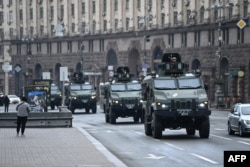 Kendaraan militer Ukraina bergerak melewati alun-alun di Kyiv tengah, 24 Februari 2022, setelah kota-kota dihantam dengan apa yang dikatakan pejabat Ukraina sebagai serangan rudal dan artileri Rusia. (Foto: AFP)