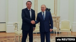 Presiden Rusia Vladimir Putin berjabat tangan dengan Presiden Brazil Jair Bolsonaro selama pertemuan di Moskow, Rusia 16 Februari 2022. (Foto: Sputnik/Mikhail Klimentyev/Kremlin via REUTERS)