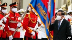  រូបឯកសារ៖ លោក​នាយករដ្ឋមន្ត្រី ហ៊ុន​ សែន (ស្ដាំ) អញ្ជើញ​ត្រួតពល​ក្នុង​អំឡុងពេល​នៃ​ការ​ប្រារព្ធ​ទិវា​ឯករាជ្យ​ជាតិ​លើក​ទី​៦៨​របស់​កម្ពុជា រាជធានី​ភ្នំពេញ ថ្ងៃទី៩ ខែវិច្ឆិកា ឆ្នាំ២០២១។ (AP Photo/Heng Sinith)