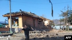 Seorang tentara Korea Selatan memberi isyarat di dekat lokasi kecelakaan bom di luar tempat latihan tembak militer di Pocheon pada 6 Maret 2025. Sebuah jet tempur secara tidak sengaja menjatuhkan delapan bom di tempat yang salah selama latihan. (Foto: Yonhap/AFP)