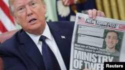 Presiden Donald Trump menunjukkan halaman depan koran New York Post kepada para wartawan sambil membahas perintah eksekutif terkait perusahaan media sosial, di Ruang Oval, Gedung Putih, 28 Mei 2020. (Foto: Reuters)