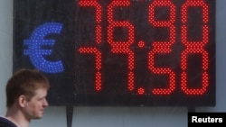 A board, showing the currency exchange rates of the euro against the Russian ruble, is on display in a street in Moscow, Russia April 10, 2018.