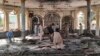 People view the damage inside of a mosque following a bombing in the provincial capital of Kunduz, northern Afghanistan, Oct. 8, 2021.
