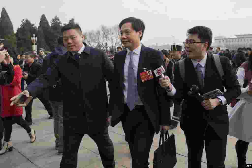 2018年3月5日,小米科技公司董事长兼首席执行官,金山软件公司董事长雷军(中)为参加全国人大开幕会议抵达人民大会堂。BBC中文记者在大会堂拦住了雷军,问他对修宪怎么看。他愣了一下,摆了下手说,“这些问题,我……抱歉,抱歉啊,抱歉抱歉”,随后快速走入了会场。 ”