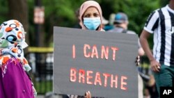 នៅក្នុងបាតុកម្មនៅថ្ងៃសៅរ៍ ទី ៣០ ខែឧសភា ឆ្នាំ ២០២០ ក្បែរ​សេតវិមាន​ក្នុង​រដ្ឋធានី​វ៉ាស៊ីនតោន ស្រ្តី​ម្នាក់​នេះ កាន់​ស្លាក​សញ្ញា​ដែល​សរសេរ​ថា «ខ្ញុំ មិន​អាច​ដក​ដង្ហើម​បាន​ទេ» ដែល​នោះ​ជា​ឃា្ល​ដែល​លោក George Floyd បាន​និយាយ​មុន​ពេល​លោក​ស្លាប់។ (AP)