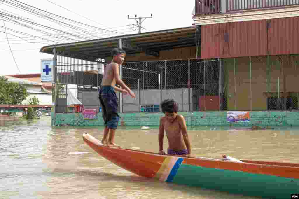 កុមារមួយក្រុមកំពុងលេងទឹកដែលជន់លិចនៅភូមិព្រែកជ្រៃ សង្កាត់ស្ពានថ្ម ខណ្ឌដង្កោ រាជធានីភ្នំពេញ ថ្ងៃទី១៥ ខែតុលា ឆ្នាំ២០២០។ (ទុំ ម្លិះ/វីអូអេ)