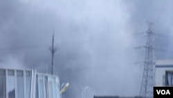 天津爆炸事故现场，核心爆炸区周围多座居民楼窗户被震碎，高速公路桥梁受损，多辆大货车被炸翻，小汽车起火或被砸，多名当地居民仍逗留在事故现场。（美国之音记者东方拍摄）