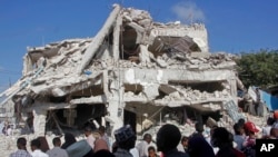 Kerabat menunggu jenazah dikeluarkan dari lokasi bangunan yang hancur, sehari setelah serangan bom mobil ganda di persimpangan ramai di Mogadishu, Somalia Minggu, 30 Oktober 2022. (AP/Farah Abdi Warsameh)