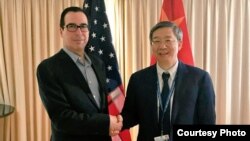 2018年10月10日，美国财政部长姆努钦和中国人民银行行长易纲在国际会议期间握手，姆努钦说双方讨论了重要经济问题（姆努钦推特图片）。