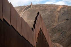 Construction crews work on a new section of the US-Mexico border fencing at El Nido de las Aguilas, eastern Tijuana, Baja California state, Mexico on Jan. 20, 2021.
