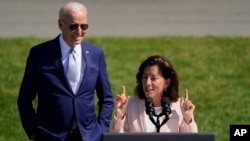 2022 年 8月9日，在白宫南草坪， 商务部长雷蒙多就拜登政府指定 31 个“科技中心”发表讲话。拜登总统在观看。