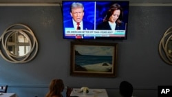 미국 캘리포니아주 오클랜드시의 식당에서 두 사람이 대선 후보 TV 토론 방송을 보고 있다. (자료사진)