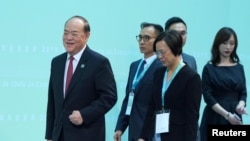 北京认可的澳门唯一的行政长官候选人贺一诚（左一）在澳门出席一个会议。 （2019年8月10日）