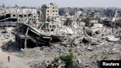 រូបថតឯកសារ៖ ជនជាតិប៉ាឡេស្ទីនអង្គុយក្បែរគំនរបាក់បែកនៃផ្ទះដែលត្រូវបានបំផ្លាញនៅក្នុងការវាយលុកយោធារបស់អ៊ីស្រាអែលនៅទីក្រុង Khan Younis នៅភាគខាងត្បូងតំបន់ហ្កាហ្សា ថ្ងៃទី៨ ខែតុលា ឆ្នាំ២០២៤។