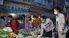 People wearing protective face masks rush to buy groceries at a fresh market amid rumors of a citywide lockdown during the latest coronavirus disease (COVID-19) outbreak at a temple in Phnom Penh, Cambodia, April 14, 2021. REUTERS/Cindy Liu