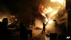 Foto yang dirilis oleh kantor berita Suriah SANA, menunjukkan kobaran api yang membakar kontainer di pelabuhan Latakia, Suriah, pada 28 Desember 2021, setelah Israel melancarkan serangan udara ke area pelabuhan tersebut. (Foto: SANA via AP)