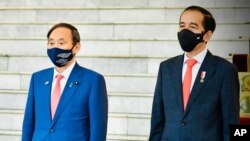 日本首相菅义伟(左)和印尼总统佐科·维多多在总统府会晤时奏国歌。（2020年10月20日）