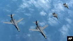 韩国空军战斗机（右三、右四）2017年6月20日伴飞美国的B-1B轰炸机（左一、左二）