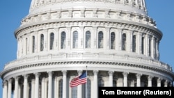 Bendera Amerika berkibar di Gedung Capitol AS, ketika Wal Kkota Muriel Bowser menyatakan keadaan darurat karena COVID-19 di Capitol Hill, Washington, AS, 18 Maret 2020. (Foto: Reuters / Tom Brenner)