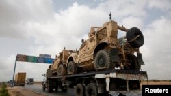 FILE - A trailer transports armored vehicles used by the North Atlantic Treaty Organization (NATO) forces during the Afghan war.