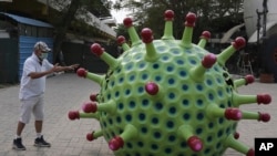 Perancang mobil dari India, K. Sudhakar Yadav, di samping mobil virus corona di museumnya sebagai bagian untuk kampanye tentang penyakit itu di Hyderabad, India, 7 April 2020. 