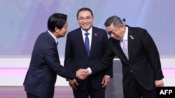 Lai Ching-te, left, Taiwanese presidential candidate from the ruling Democratic Progressive Party, shakes hands with Ko Wen-je, candidate from the Taiwan People’s Party, as Hou Yu-ih, candidate from the Kuomintang Party, looks on during a debate in Taipei on Dec. 30, 2023.
