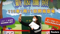 一名台北妇女在台湾新版护照发布广告前自拍留念。（2021年1月11日）