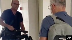 Seorang petugas Israel (kiri) tampak menyita peralatan video milik kantor berita AP dari blok apartemen di kota Sderot, Israel Selatan, hari Selasa, 21 Mei 2024.