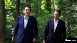 រូបឯកសារ៖ នាយករដ្ឋមន្ត្រី​ជប៉ុនលោក Fumio Kishida និង​ប្រធានាធិបតី​កូរ៉េខាងត្បូង​លោក Yoon Suk Yeol ដើរ​អម​គ្នា​នៅក្នុង​ជំនួប​មួយ​ជាមួយ​ប្រធានាធិបតី​សហរដ្ឋអាមេរិក ក្នុងទីក្រុង Thurmont រដ្ឋ Maryland កាលពីថ្ងៃទី១៨ ខែសីហា ឆ្នាំ២០២៣។