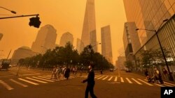 Para pejalan kaki bergerak melewati One world Trade Center di New York, pada 7 Juni 2023, di tengah asap dari kebakaran hutan di Kanada yang menyelimuti kota tersebut. (Foto: AP/Julie Jacobson)