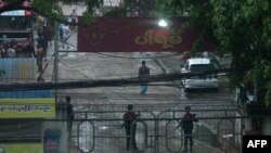 FILE - Security forces stand guard by entrance gates following an explosion at a bus station in South Okalapa township in Yangon, April 6, 2021, amid a crackdown on protests against the military coup. 