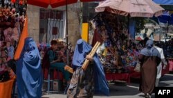 Perempuan Afghanistan berpakaian burqa berbelanja di area pasar di Kabul pada 23 Agustus 2021, setelah militer Taliban mengambil alih negara itu. (Foto: AFP)