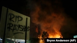 黑人男子雷沙德·布鲁克斯被射杀现场所在的温蒂汉堡快餐店在6月13日的抗议中被烧。牌子上有人喷漆，写上“雷沙德安息”。