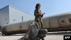 A member of the Israeli military stands next to an Iranian ballistic missile which fell in Israel on the weekend, during a media tour at the Julis military base near the southern Israeli city of Kiryat Malachi on April 16, 2024.